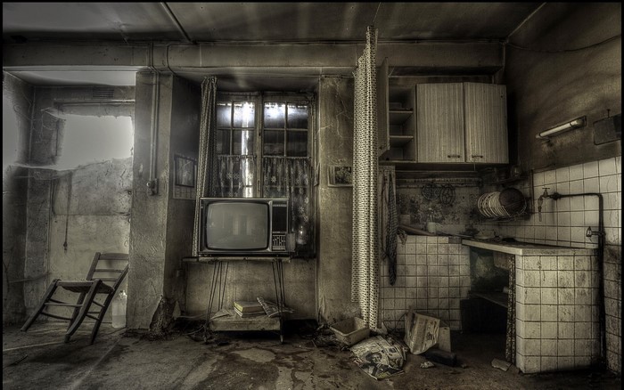 Abandoned room with old TV and kitchen