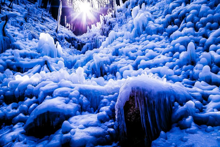 Sunlight shining through ice formations on a slope