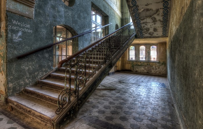 Abandoned building interior with ornate staircase