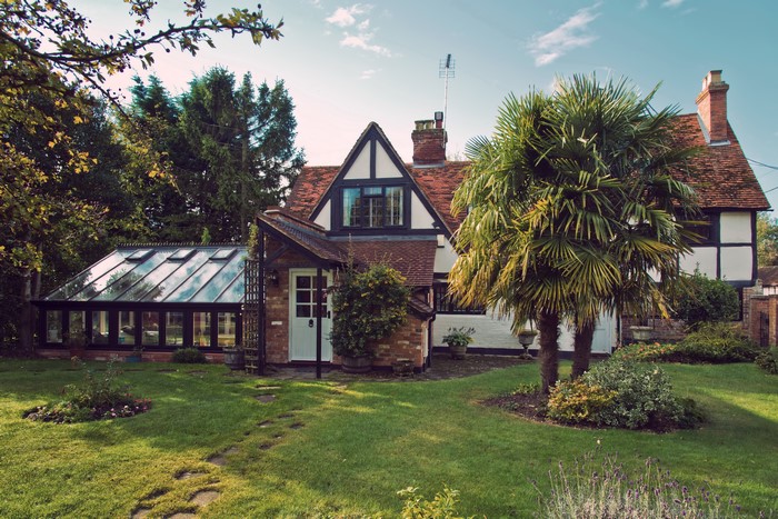 Tudor-style house with conservatory and palm trees