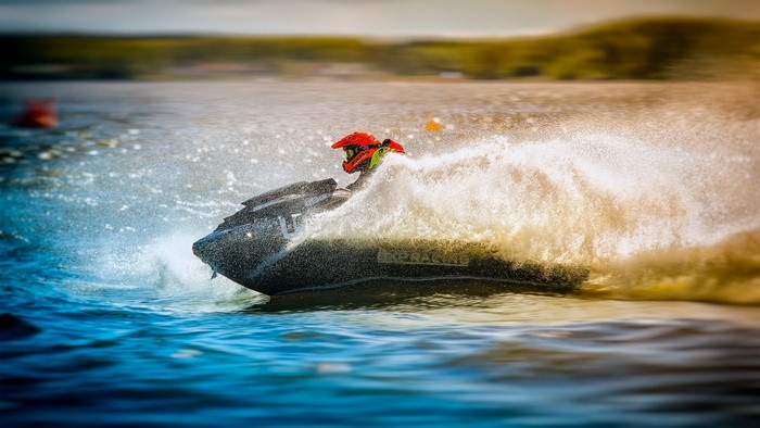 Person in helmet riding a jet ski on water