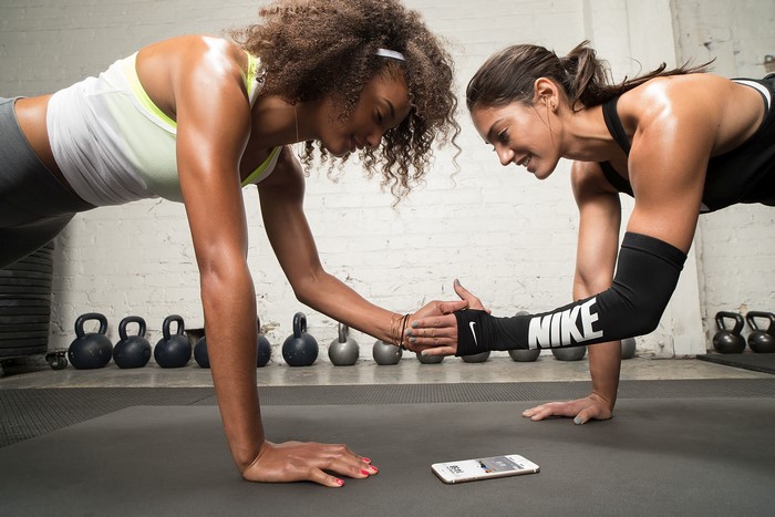 Two women doing push-ups in a gym