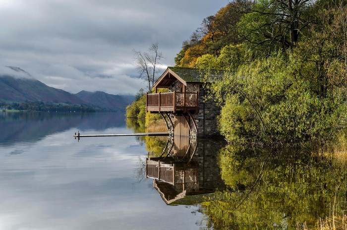 Boathouse on a lake with mountains in the background
