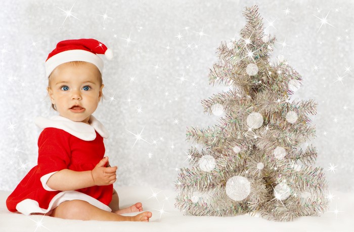 Baby in Santa costume with Christmas tree