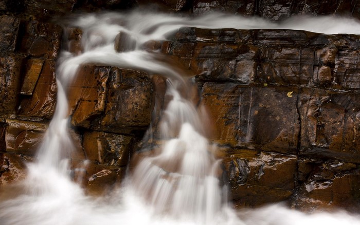 Water flowing over brown rocks