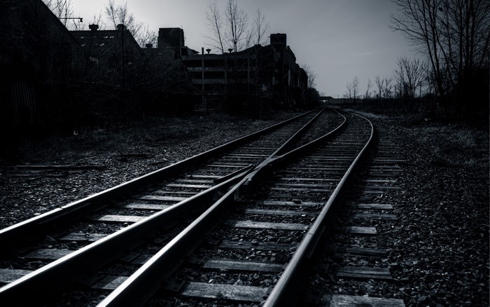 Abandoned railroad tracks leading to industrial buildings