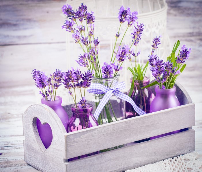 Lavender in purple vases in a wooden crate