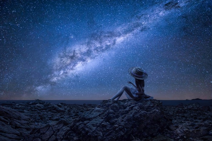 Woman in hat looking at the Milky Way