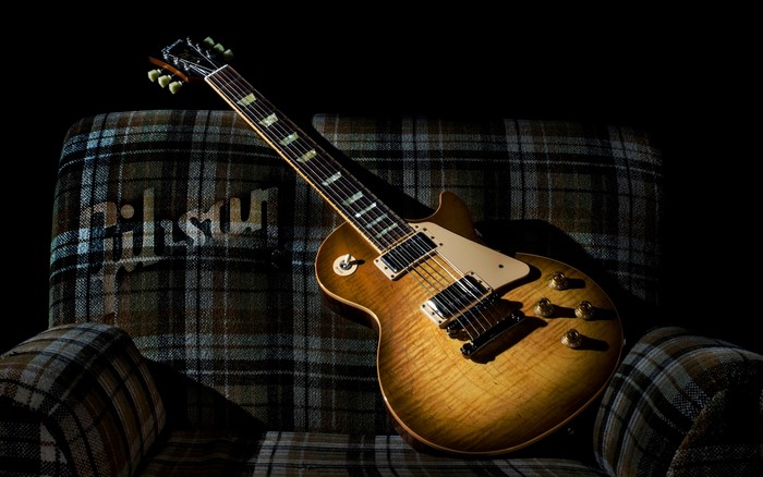 Gibson electric guitar on a plaid armchair