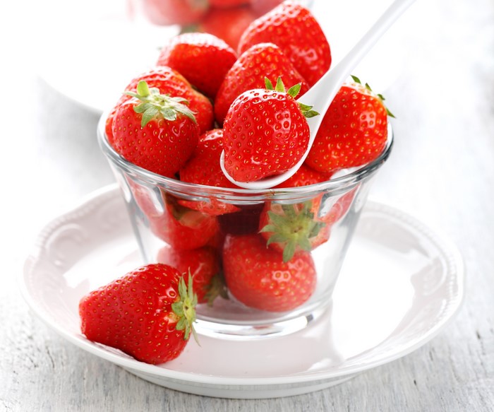 Strawberries in a glass bowl on a plate