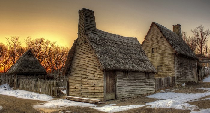 Historic village with thatched-roof houses in winter at sunset