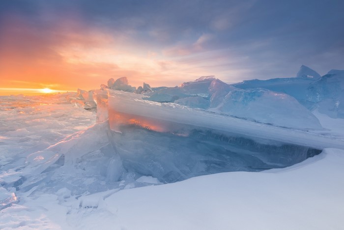 Ice formations on a frozen lake at sunset