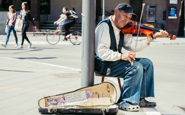 Elderly man playing violin on street