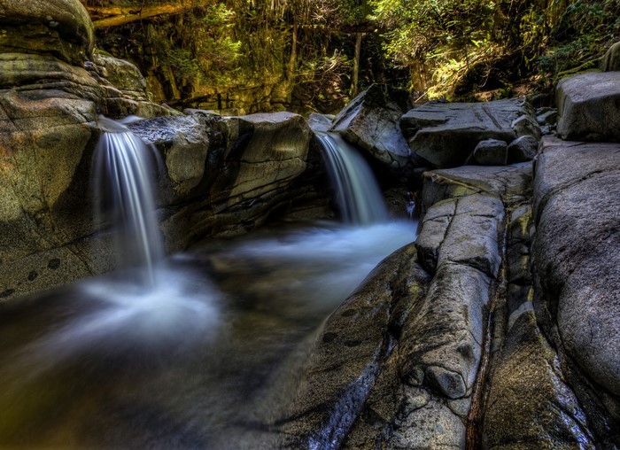 Waterfalls cascading over rocks in a forest