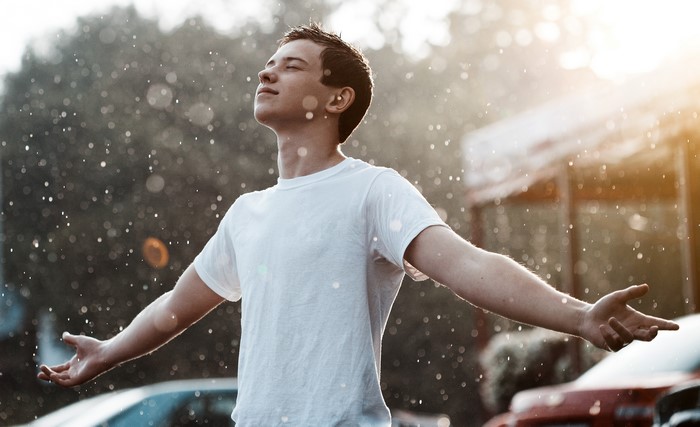 Man in white t-shirt standing in the rain