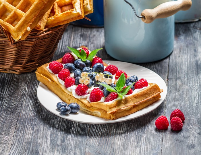 Waffle with cream and fresh berries on a plate
