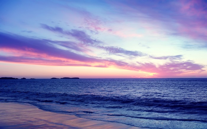 Ocean sunset with colorful clouds and islands