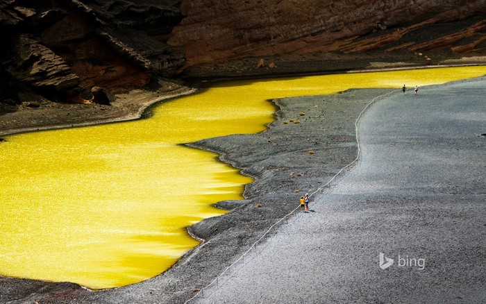 Yellow lake and rocky landscape with people