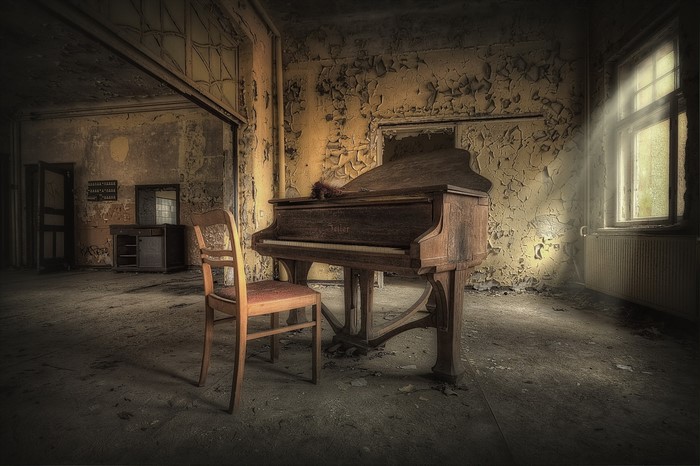 Abandoned room with a grand piano and chair