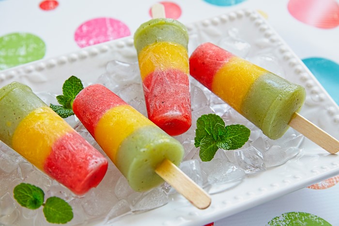Layered fruit popsicles on ice