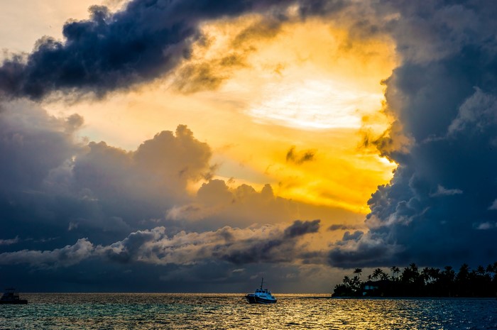 Dramatic sunset over the ocean with a boat and island