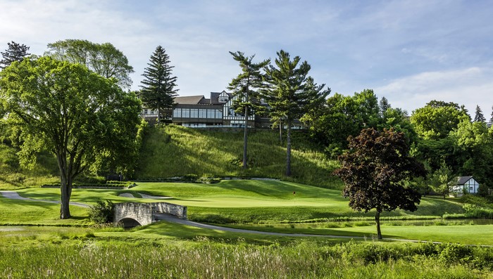 Golf course with a bridge and a building in the background