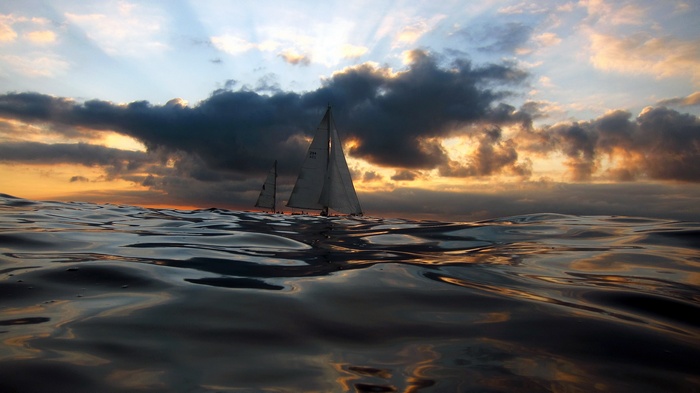Sailboats on the ocean at sunset