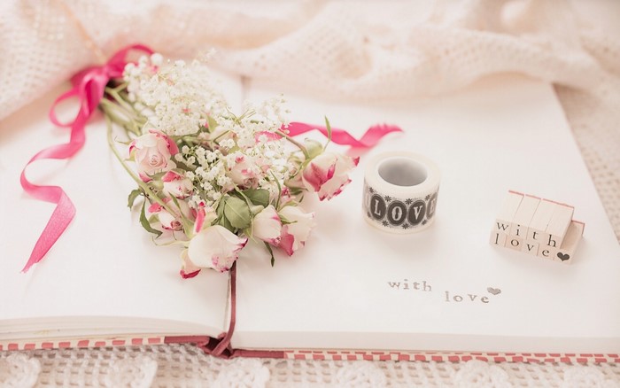 Bouquet of roses on an open book with love stamps