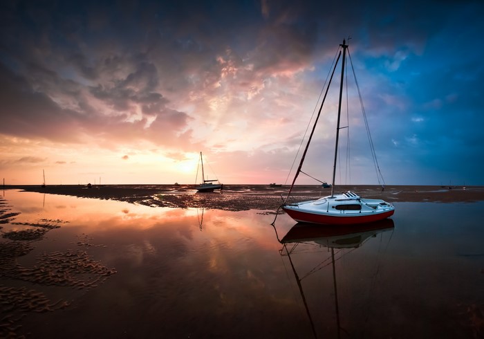 Boats on a beach at sunset in Great Meols, England