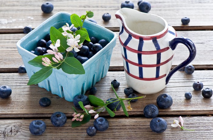 Blueberries in a basket with a pitcher