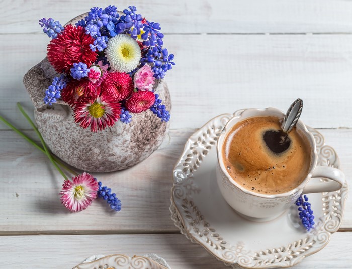 Coffee cup with flowers and vase