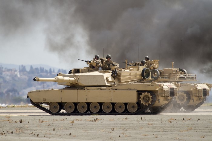 M1A1 Abrams tanks with soldiers in smoke