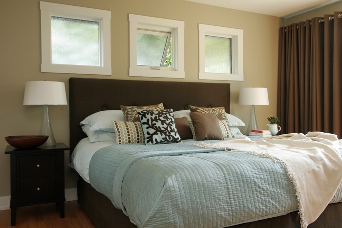 Bedroom with bed, lamps, and windows