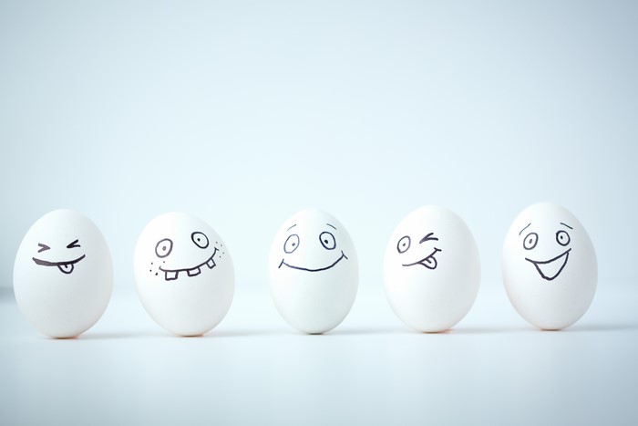 Five Easter eggs with drawn faces in a row