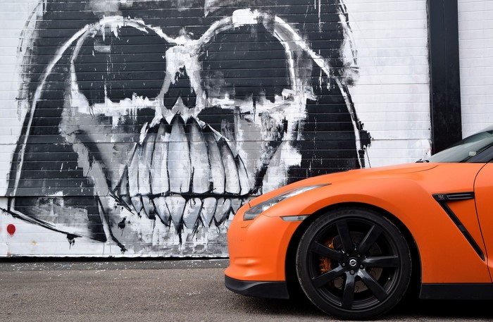 Orange Nissan GTR in front of Darth Vader Graffiti