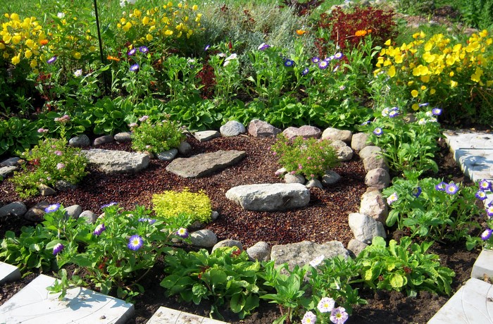Flower garden with stones and paving stones
