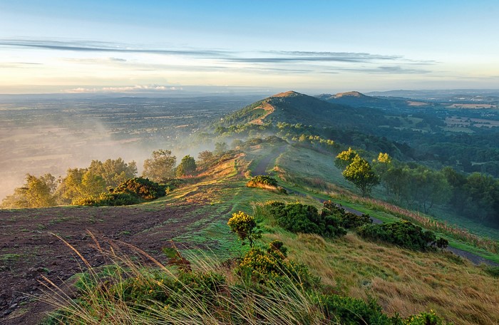 Misty mountain ridge with a trail at sunrise