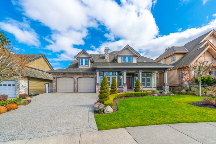 Luxury house with manicured lawn and blue sky
