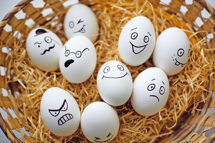 Easter eggs with faces in a wicker basket