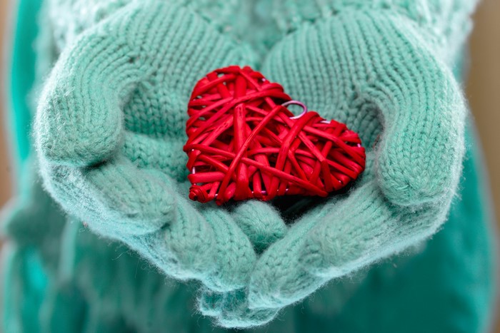 Hands in Gloves Holding Red Heart
