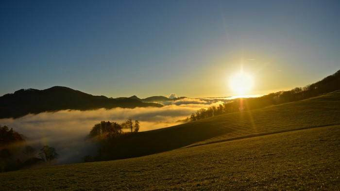 Sunrise over foggy mountains and grasslands