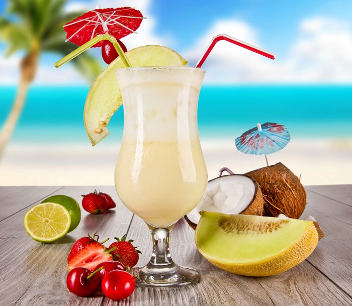 Tropical cocktail with fruits on a beach background