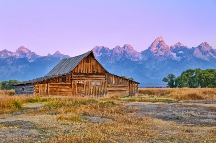 Wooden barn in front of the Teton Mountains at sunrise