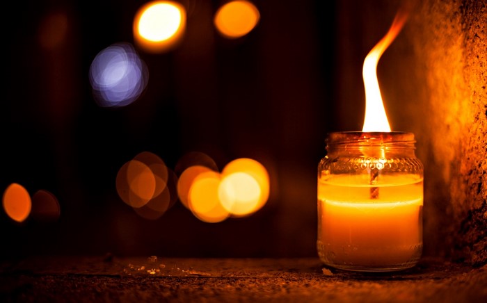 Candle burning in a glass jar at night