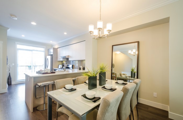 Dining room and kitchen interior with chandelier and table