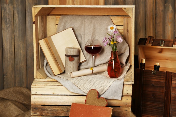 Still-life with wine, book, candle, and flowers