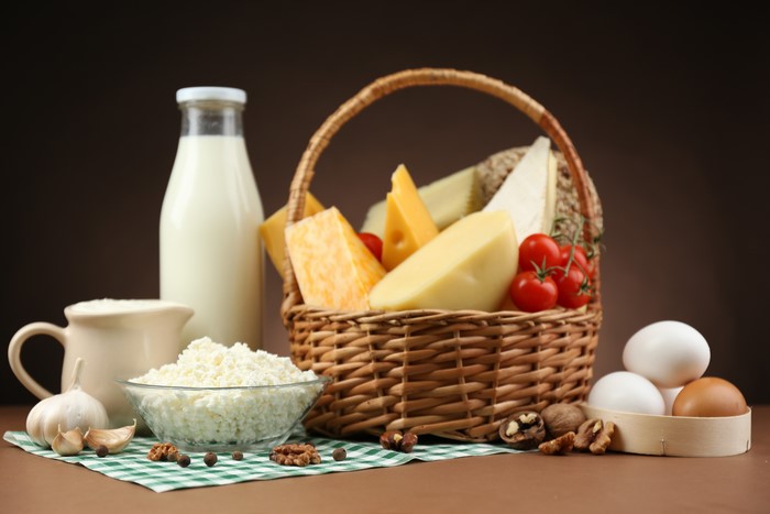 Dairy products, eggs, and tomatoes in a basket