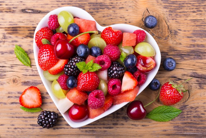 Heart-shaped bowl of fresh berries and fruit