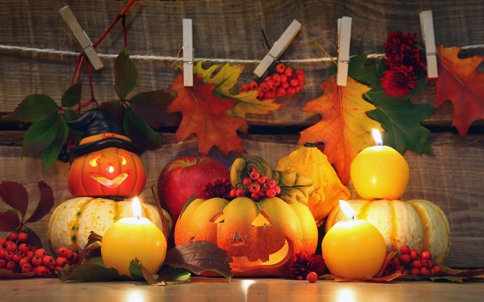 Halloween pumpkins and candles with autumn leaves