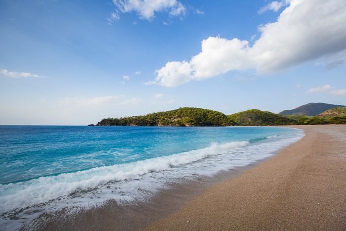 Beach with turquoise water and green hills